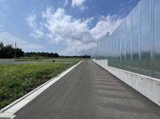 幅員がしっかりと確保された前面道路が印象的です。アスファルト舗装が新しく車両の通行もスムーズに行えます。隣接する敷地も開放的で周囲の見通しが良好です。道路の両側には整った歩道が設置されています。