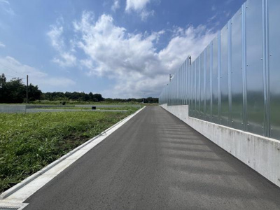 幅員がしっかりと確保された前面道路が印象的です。アスファルト舗装が新しく車両の通行もスムーズに行えます。隣接する敷地も開放的で周囲の見通しが良好です。道路の両側には整った歩道が設置されています。