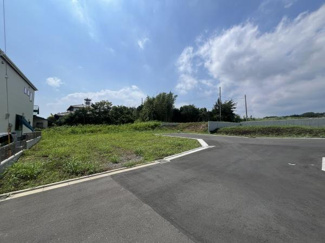 現地の前面道路は広々とした印象で進入や出入りがしやすい配置となっています。周辺には開放感のある景観が広がり視界が抜けているのが特徴です。隣接する建物も少なくゆとりを感じさせる現地写真です。