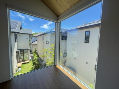 大きなコーナー窓から明るい光が差し込み開放感のある現地からの眺望が楽しめます。周囲の住宅街の様子がよく見え空の広がりも感じられる空間です。窓際から季節の移ろいも感じ取ることができます。