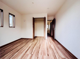 収納スペースがしっかり確保されているお部屋です。フローリングと建具の木目調が統一感を演出します。窓からの光が差し込む明るい雰囲気が特徴です。室内の動線がすっきりとしており使いやすい間取りです。