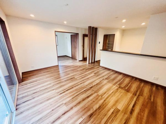 広々としたリビング空間が開放的な印象を与えます。木目調のフローリングが温かみを感じさせます。ダウンライトが室内を明るく照らし快適な環境を実現します。カウンター付きで空間にアクセントを加えています。