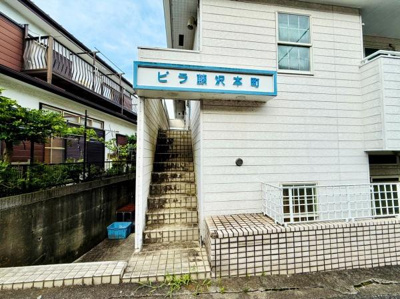 建物外壁は明るい色合いで清潔感があります。エントランス部分の屋根付き通路が特徴的です。階段は屋外に設置されており通りからのアクセスも便利です。敷地は舗装されていて歩きやすいです。