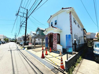 前面道路が広く車の出し入れがしやすい現地写真です。落ち着いた住宅街の雰囲気が感じられます。建物の外観が特徴的で印象に残ります。カースペースが確保されており利便性もあります。