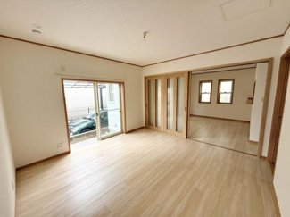 大きな窓から自然光がたっぷりと差し込むリビングです。隣接した空間とのつながりを感じられる引き戸が特徴的です。シンプルな内装でお好みに合わせたアレンジが可能です。床は温かみのある木目調です。