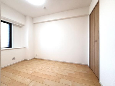 明るい色合いのフローリングが特徴の洋室です。収納スペースも備わっておりすっきりとした空間です。窓から自然光が入るため室内が明るく感じられます。シンプルな内装で自分好みにアレンジしやすい洋室です。
