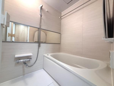 シンプルな内装が清潔感を感じさせるバスルームです。ワイドなミラーが空間に広がりを演出します。シャワーや蛇口も使いやすい高さに設置されています。浴槽はゆったりとしたサイズ感です。