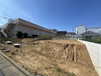 日当たりの良い現地土地写真です。周辺には生活関連施設が集まっています。土地の形状も確認しやすく敷地の使い方を検討しやすい環境です。道路に面しておりアクセスも便利です。