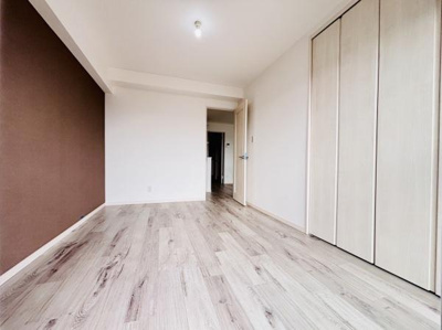 ナチュラルな色合いのフローリングで空間がすっきり感じられます。アクセントクロスが一面に施されメリハリのある内装です。収納スペースも扉付きで見た目が整っています。