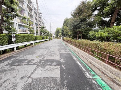 歩道の緑が印象的な道路沿いの環境です。建物の前には整えられた植栽が並び街並みが整然としています。周囲には緑が多く落ち着いた雰囲気を感じられます。自転車なども利用しやすそうな広さの道幅です。