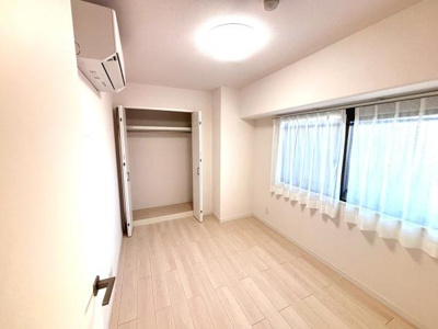 クローゼット付きの居室で収納スペースがしっかり確保されています。明るい床材がお部屋全体を広く感じさせます。窓が大きく自然光がたっぷり差し込みます。白を基調とした内装ですっきりとしています。