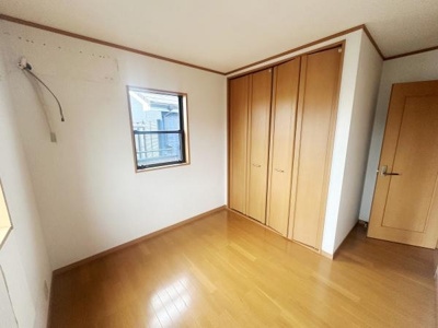 洋室には明るい窓があり日差しがしっかり入ります。木目調のクローゼットが備え付けられており収納も十分です。建具の色合いが床と調和して落ち着いた雰囲気を感じられます。扉も同系色で統一されています。