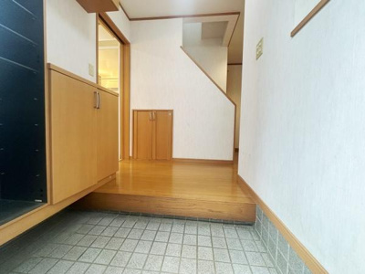 清潔感のある玄関ですっきりとした印象です。収納スペースが備わっており整理整頓しやすい造りです。木目調の下駄箱がアクセントとなっています。段差付きで屋内と屋外をしっかり区切っています。