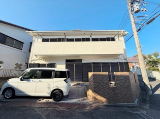 白を基調とした外観が清潔感を演出しています。広いバルコニーが印象的な建物です。駐車スペースも確保されています。前面道路からのアクセスも便利です。シンプルで落ち着いたデザインが特徴です。