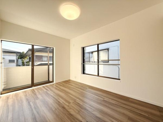 大きな窓から光が差し込む明るい洋室です。開放感のある空間でさまざまなインテリアが楽しめます。床材は落ち着いた色合いでお部屋全体の雰囲気を引き立てます。シンプルな内装がすっきりとした印象を与えます。