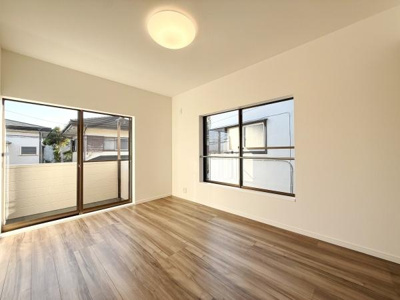 大きな窓から光が差し込む明るい洋室です。開放感のある空間でさまざまなインテリアが楽しめます。床材は落ち着いた色合いでお部屋全体の雰囲気を引き立てます。シンプルな内装がすっきりとした印象を与えます。