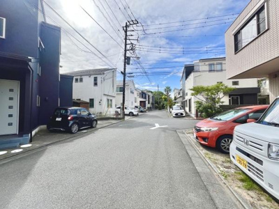 周辺は住宅が立ち並び明るい雰囲気の通りです。道幅がしっかりと確保されており車の出入りもスムーズです。前面道路が整備され車の通行にも安心感があります。整った街並みが感じられる一枚です。