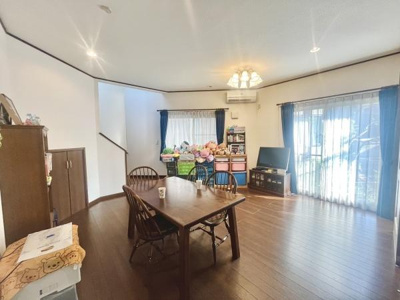 リビングは広々とした空間で明るい日差しが差し込みます。大きな窓が印象的で開放感があります。床や建具は落ち着きのある色合いです。