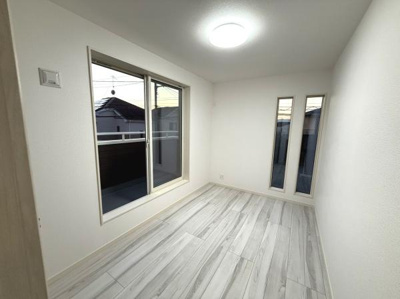 大きな窓からたっぷりと光が差し込み明るい洋室です。シンプルな内装で家具のレイアウトがしやすいお部屋となっています。床材のデザインもスタイリッシュな印象を与えます。