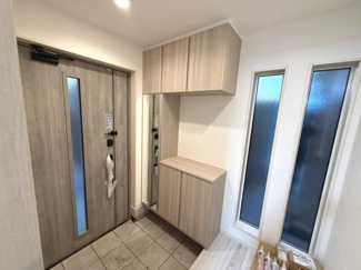 玄関に大きな窓があり自然光がしっかりと入ります。明るい雰囲気が印象的です。収納スペースが豊富で整理整頓がしやすそうです。シンプルなデザインで空間に清潔感があります。