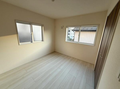 二面採光で明るい洋室です。ナチュラルな色合いのフローリングが空間を広く感じさせます。収納スペースも設けられており使い勝手に配慮されています。シンプルな内装で様々なインテリアに合わせやすい洋室です。
