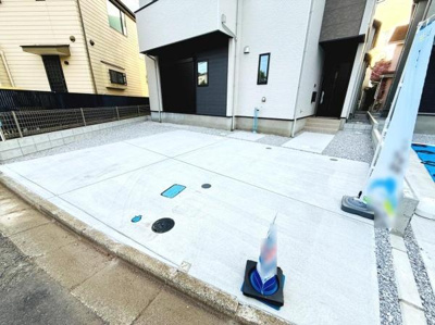駐車場は幅広く設計されており出入りもスムーズです。地面はコンクリート仕様で雨にも強くメンテナンスもしやすい状態です。住まいの正面にゆとりあるスペースが確保され使い勝手が良好です。