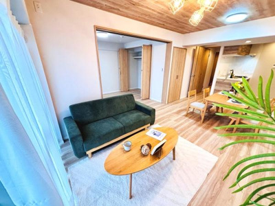 開放感のあるリビングは落ち着いたグリーンのソファと木目調のインテリアが調和しています。床や天井にも木の温もりが感じられゆとりのある空間設計です。