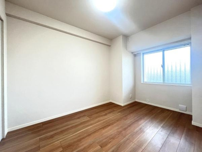 ナチュラルな色合いのフローリングが空間を明るく演出します。大きな窓から自然光が差し込み室内全体が開放的な印象です。シンプルな内装でアレンジがしやすい洋室です。天井も高めで圧迫感を感じにくい設計です。