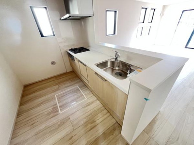 明るい空間が広がるキッチンです。複数の窓があり自然光が差し込みます。カウンターがシンプルにまとまっています。木目調の床で温もりも感じられます。開放感のあるレイアウトも特長です。