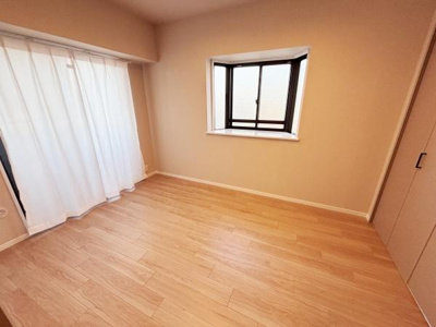 窓から光が入る明るい洋室です。シンプルな内装で好みに合わせたインテリアが楽しめます。収納スペースも備わっており使い勝手が良いお部屋です。床は木目調で温かみを感じられます。