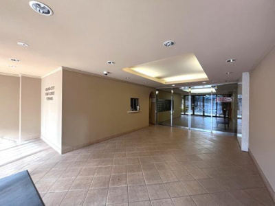 広々としたロビーは開放感があります。天井の照明が空間を明るく照らします。清潔感のあるタイル張りの床が特徴です。エントランスからロビーへの視認性も高く安心感があります。受付窓口も設置されています。