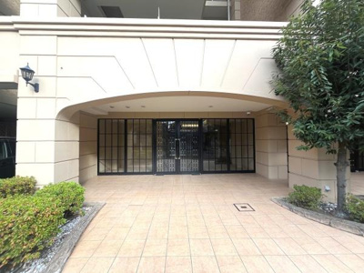 エントランスは広々とした作りでゆったりとした印象です。タイル張りの床が清潔感を演出しています。植栽がほどよく配置され建物の雰囲気によく調和しています。