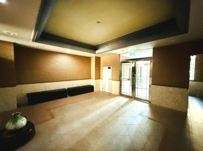 開放感のあるロビーが来客を迎えます。落ち着いた色合いの内装でゆったりとした空間が広がっています。ベンチが設置されており待ち時間にも便利です。窓から自然光が差し込み明るさが感じられるロビーです。