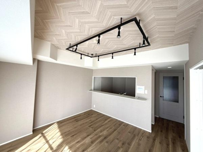 天井のデザインが印象的なリビングです。照明がアクセントとなり空間に雰囲気を加えています。明るい床材が室内を引き立て全体的に落ち着いたトーンでまとまっています。開放的なカウンターが目を引きます。