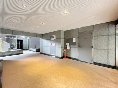 広々とした印象のロビーです。壁面には掲示板や案内板が設置されており情報が見やすい造りです。落ち着いた色合いの内装で清潔感があります。天井には多くの照明が配置されています。