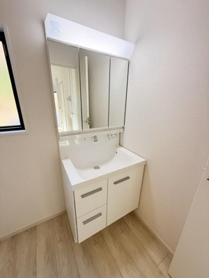 シンプルで清潔感のある洗面台が設置されています。鏡面収納が備わっており小物の整理も便利です。明るい空間で朝の身支度も快適に行えます。窓から自然光が差し込む設計です。