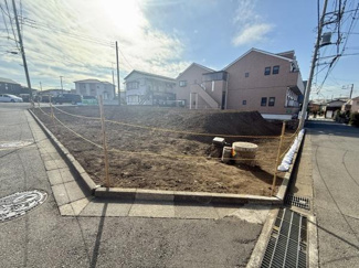 角地に位置する土地の現地写真です。周囲の道路が広く開放感のあるロケーションとなっています。陽当たりや交通のアクセスにも配慮された区画です。建築計画の立てやすい整形地です。