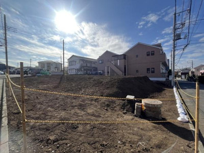 陽当たりの良い現地土地写真です。周囲には住宅が立ち並び整った街並みが広がっています。